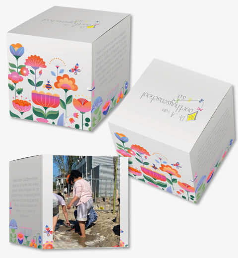 Voorbeeld van het doosje die voor Voorthuijsenschool is ontwikkeld. De buitenzijde is met gezellig gekleurde bloemen en vlinders en een foto van de kinderen in het zand